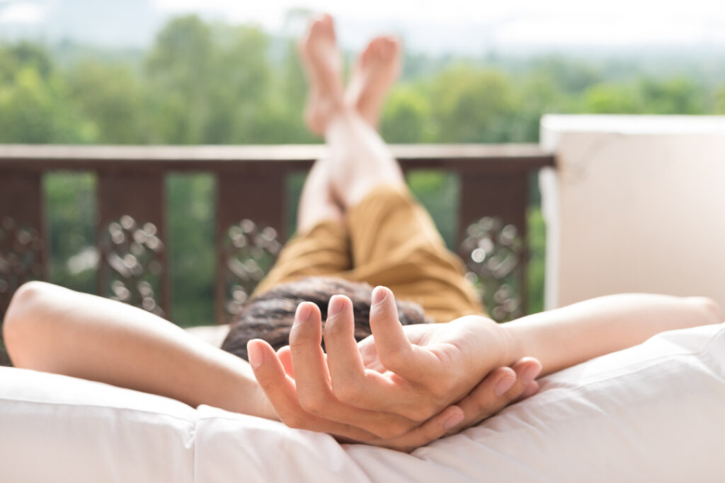 Jovem desfruta de um momento tranquilo na sacada, apreciando a vista e desconectando-se para recarregar - momentos sem tela.