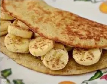 Imagem de uma deliciosa Crepioca de Banana sobre uma mesa, recheada de rodelas de banana e salpicada com canela, destacando o equilíbrio entre sabor e nutrição.