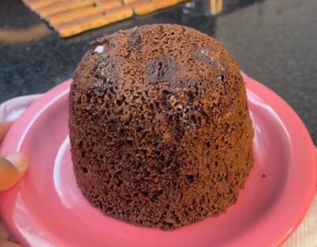 Bolinho saudável de caneca em um prato, destacando a textura macia, pedaços de chocolate derretido, uma opção nutritiva para momentos de indulgência consciente.