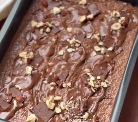 A imagem mostra a finalização do preparo do brownie antes de ser levado ao forno.