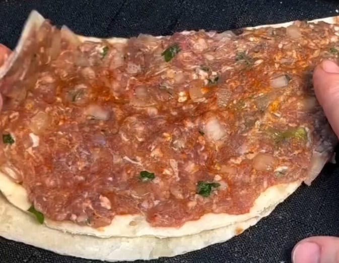 Imagem da tortilha sendo coberta com o recheio.
