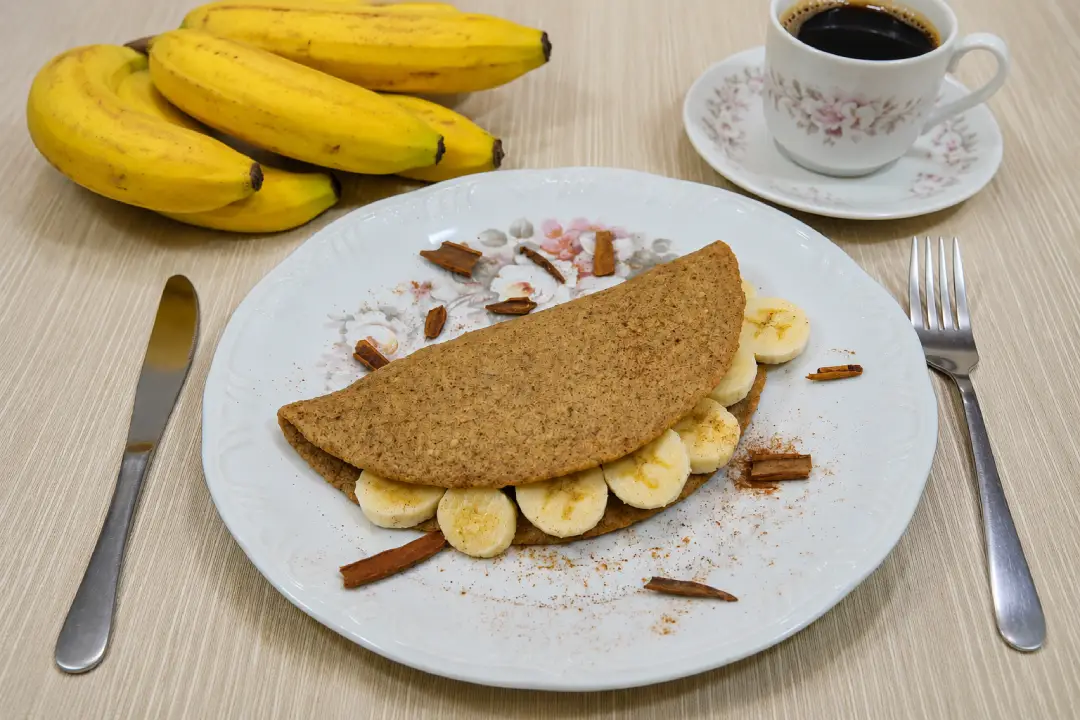 Crepioca de banana saudável servida com rodelas de banana e canela.